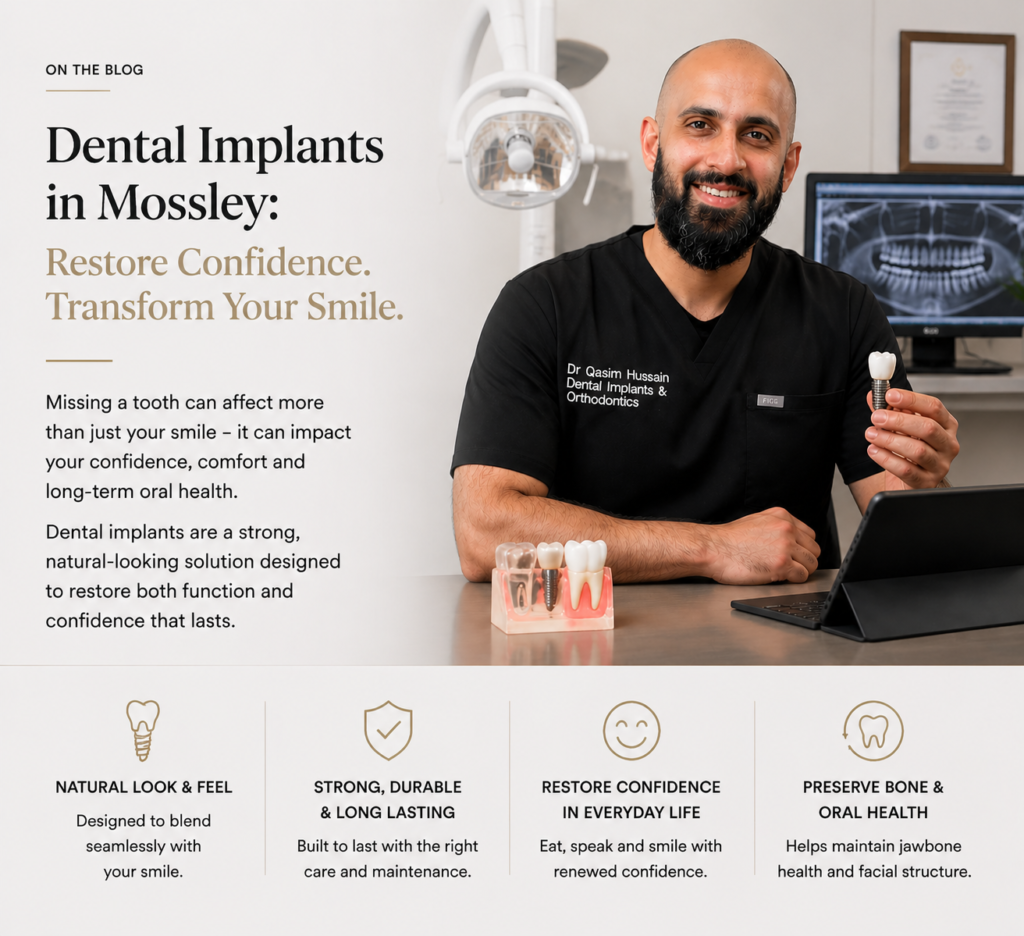 Dr. Qasim Hussain smiling in a Mossley dental clinic, holding a dental implant model, with a computer showing implant graphics in the background, illustrating dental implants for patients.
